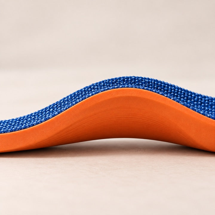 The curved arch profile of a blue and orange insole